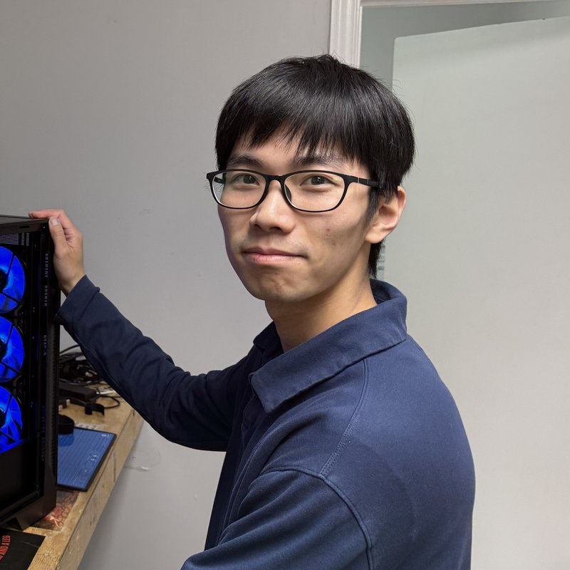 Liam beside a computer he is working on